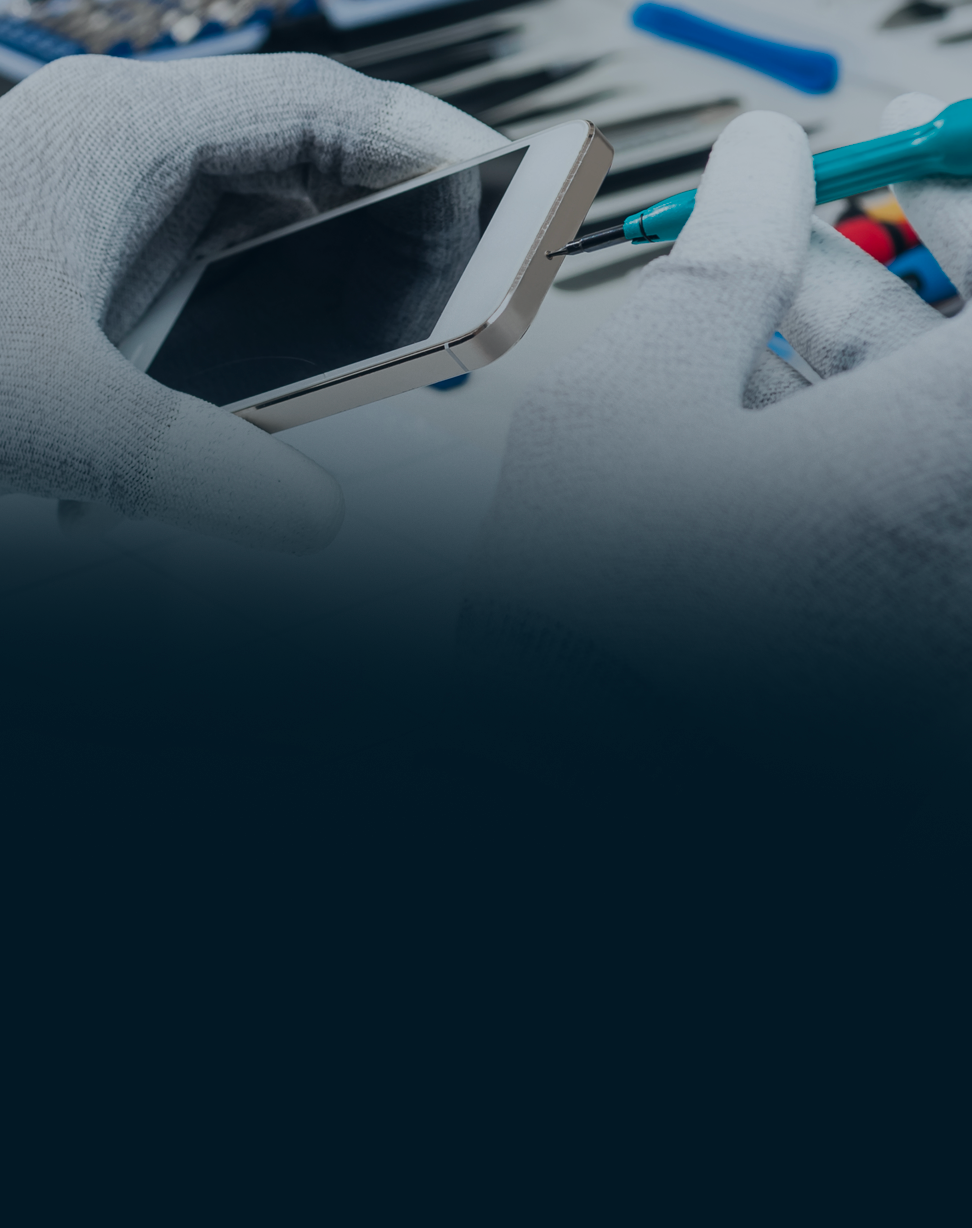 Person wearing gloves holding a smartphone with tools in the background